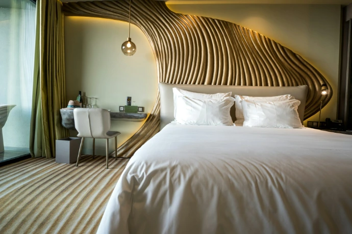 A bedroom with a white bed and a wooden headboard